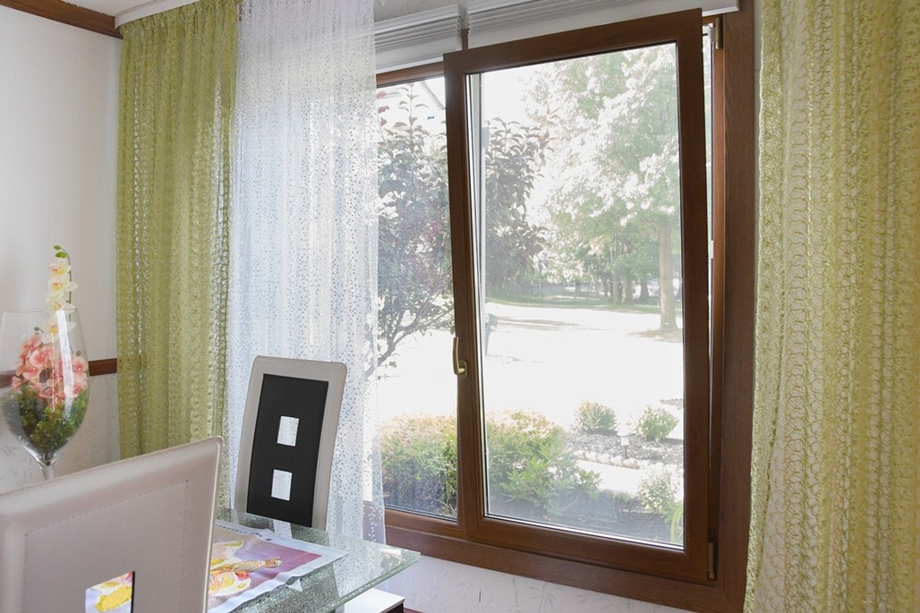 Tilt-turn window with wood-grain finish in a sunlit room